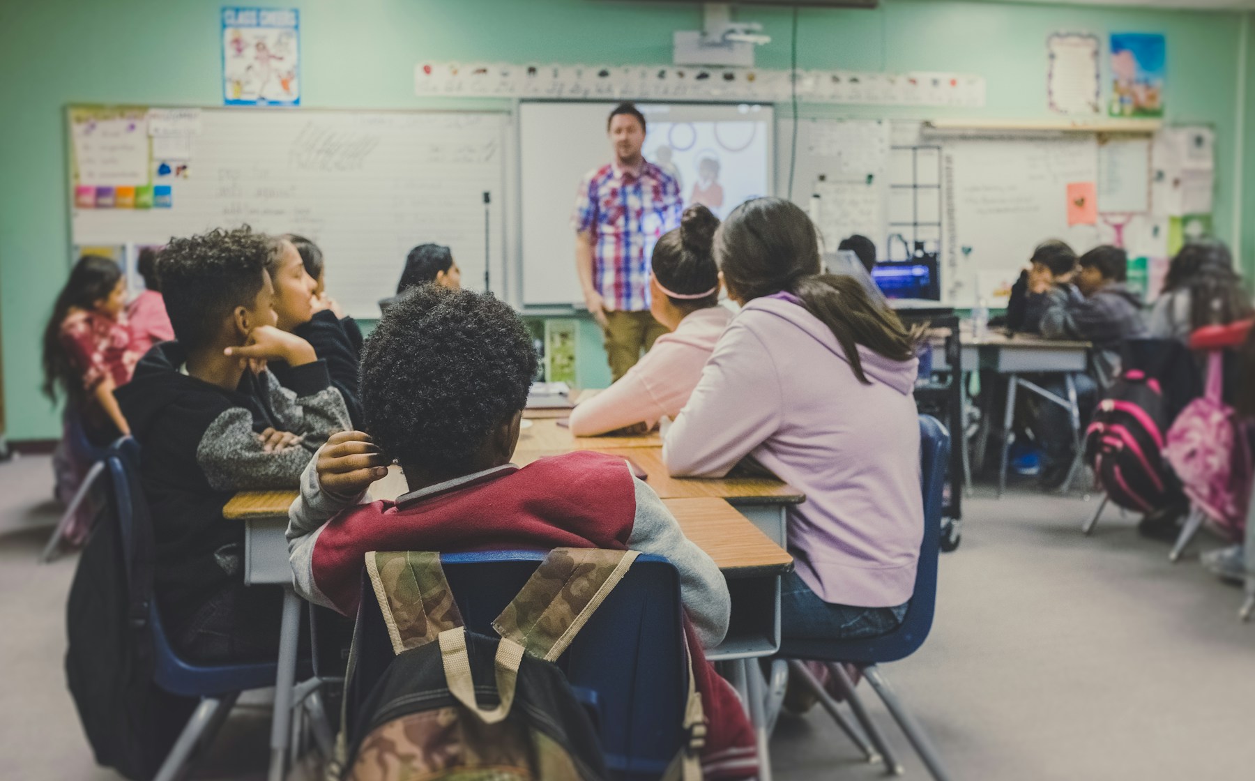 Teacher guiding pupils in a classroom learning session